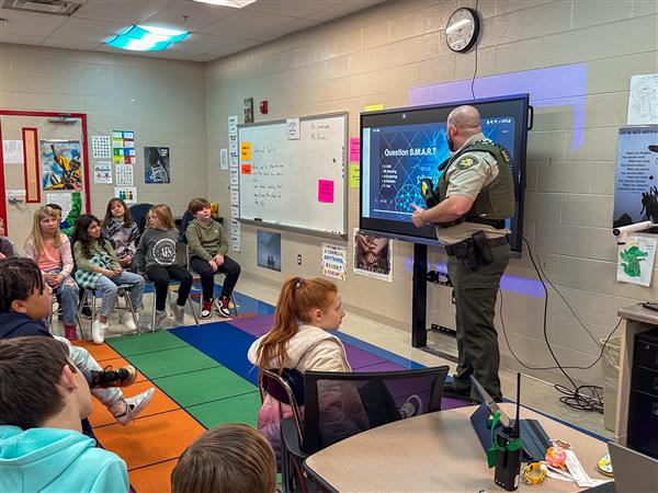 police officer talking to class of students